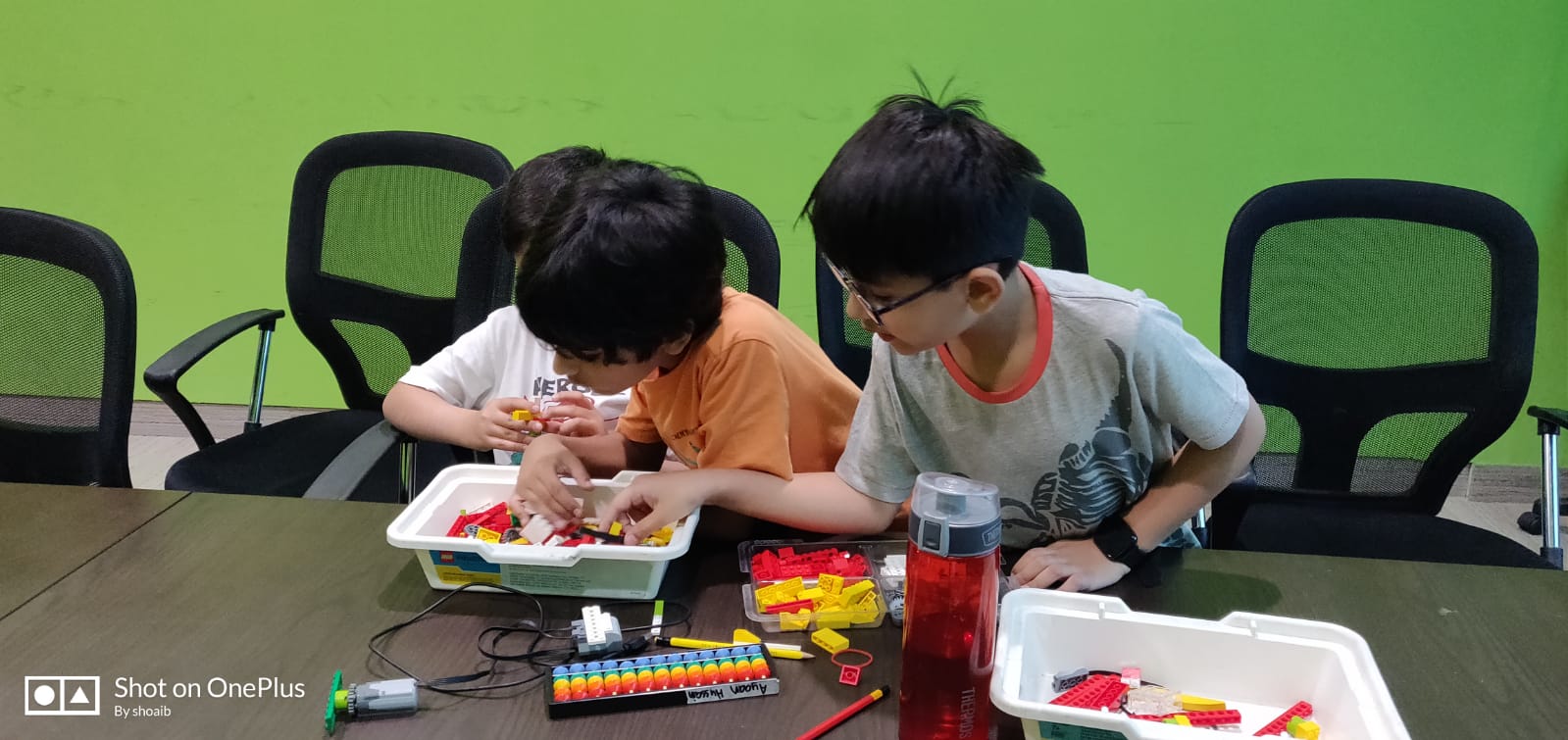 Two kids working together on a snap-together robotics build